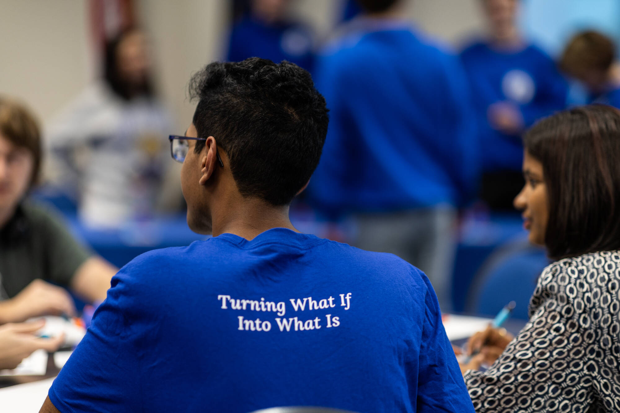 Student Senator turned around with "Turning What If Into What Is" on the back of their shirt.